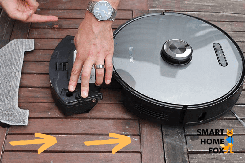 Wischtuch, Wischplatte und Wassertank liegen hinter dem Proscenic M8 PRO und ein Pfeil zeigt, wie die Komponenten ineinander gesteckt werden sollen.